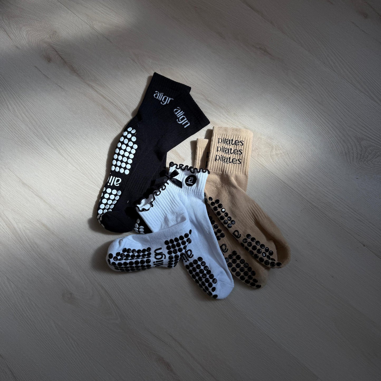 Three pairs of socks on a wooden floor with visible brand labels.