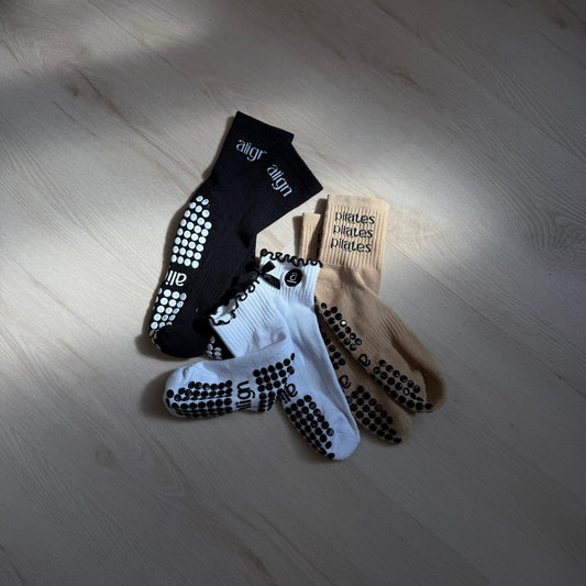 Three pairs of socks on a wooden floor with visible brand labels.